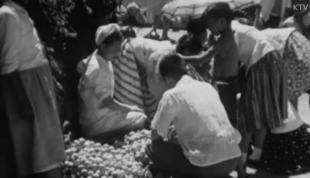 1957년 여름: 과일 좌판 앞의 상인과 시민